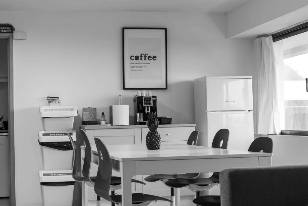 Interior do escritório da Lava em preto e branco chique, destacado por um pôster de café, simbolizando a mistura de criatividade e energia que impulsiona nossas estratégias de web e branding.